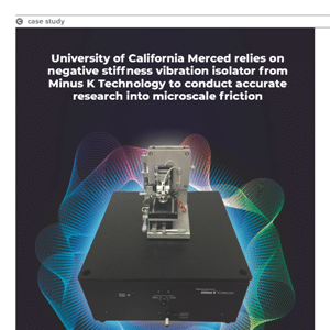 A vibration isolator device sits on a black platform, with a caption describing its use in microscale friction research at University of California Merced.